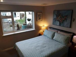 Schlafzimmer mit einem Bett und einem Fenster in der Unterkunft Lotus House in Needingworth