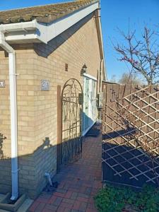un edificio di mattoni con un cancello sul lato di Lotus House a Needingworth
