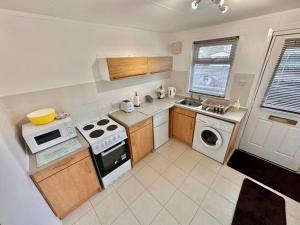 uma pequena cozinha com fogão e micro-ondas em Semi-detached 1-Bedroom Chalet em Uddingston
