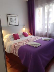 マドリードにあるGran Vía 55 Exclusive Apartmentsのベッドルーム(紫の毛布を使用した大型ベッド1台付)