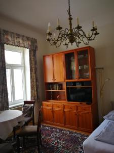 ein Schlafzimmer mit einem großen Holzschrank und einem TV in der Unterkunft Garconniere im ehemaligen Hotel Austria in Gmunden