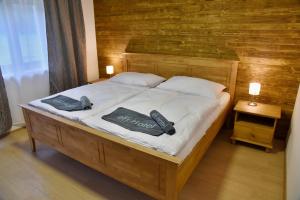Un dormitorio con una cama con dos controles remotos. en EFI ApartHotel Horní Lipová en Lipova Lazne