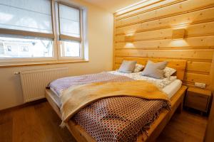 a bedroom with a bed with a wooden wall at Na Bogówce in Zakopane