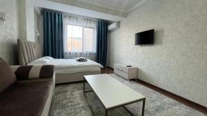 Cette petite chambre comprend un lit et un canapé. dans l'établissement Apartament Manasa, à Bishkek