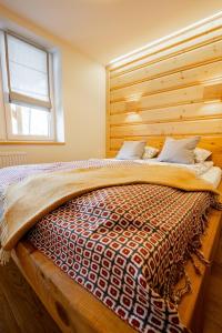 a bedroom with a bed with a wooden wall at Na Bogówce in Zakopane