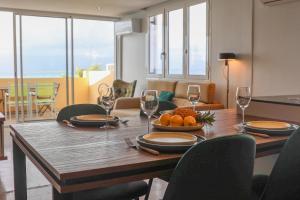 a dining room table with wine glasses and oranges on it at Le Coco in Le Gosier