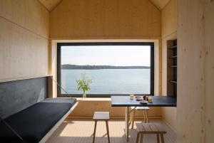 a small room with a table and a large window at Majamaja Helsinki off-grid retreat in Helsinki