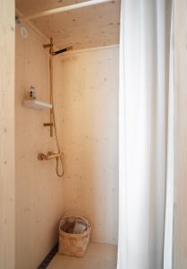 a shower in a room with a curtain at Majamaja Helsinki off-grid retreat in Helsinki