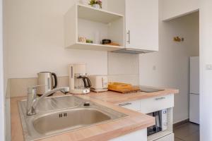 a kitchen with a sink and white cabinets at Jolie petite maison de ville Bordeaux in Bordeaux +6 photos