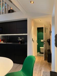 een keuken met zwarte kasten en een groene deur bij Bokrijklodge in Hasselt