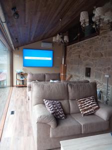 a living room with a couch and a tv at Casa de Crabera in A Coruña