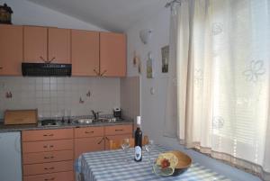 a kitchen with a table with a bowl of fruit on it at Apartment Rama in Poreč