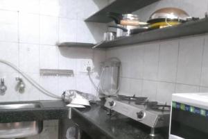 a kitchen with a sink and a stove in it at A rustic earthy home A1 in Mumbai