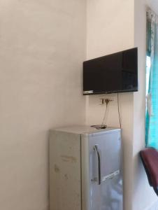 Elle comprend un réfrigérateur et une télévision à écran plat. dans l'établissement A rustic earthy home A1, à Mumbai