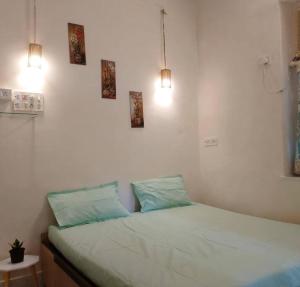 a bed in a room with three pictures on the wall at A rustic earthy home A1 in Mumbai
