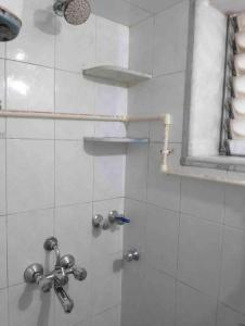 La salle de bains est pourvue d'une douche avec une porte en verre. dans l'établissement A rustic earthy home A1, à Mumbai