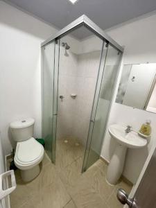 een badkamer met een douche, een toilet en een wastafel bij Apto amoblado Melgar con Piscina in Melgar
