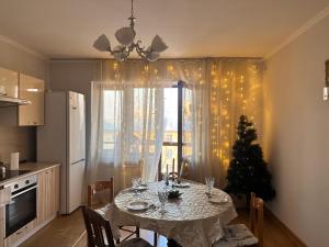 cocina con mesa de comedor y árbol de Navidad en Двух комнатная квартира возле Арбат en Almaty