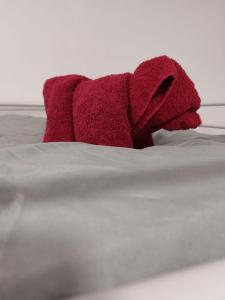 un peluche rosso sdraiato sopra un letto di FeWo Gartenblick a Thale