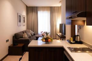a kitchen and a living room with a couch at Dream Residence Olaya Khobar-Serviced apartments in Al Khobar