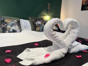 Una cama con dos cisnes hechos para parecer corazones en White Castle - Charleroi Airport en Charleroi