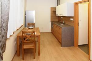 a small kitchen with a wooden table and a sink at EFI ApartHotel Horní Lipová in Lipova Lazne