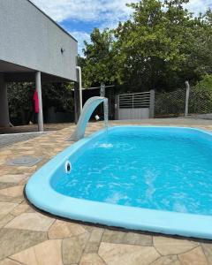 una piscina con un tobogán de agua en un patio en Chácara Recanto da Paz, en Caldas Novas