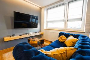 a living room with a blue couch and a television at Na Bogówce in Zakopane