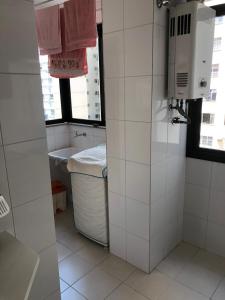 a white bathroom with a sink and a window at Apartamento localizado no melhor ponto da cidade! in Niterói