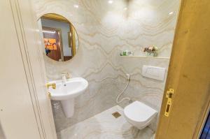 a bathroom with a sink and a toilet and a mirror at Royalton - Chic 2BR Marina Pinnacle Apartment with City Views in Dubai