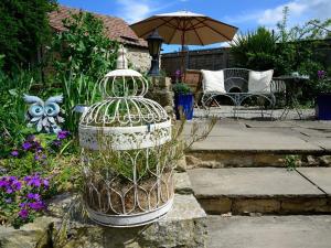 una gabbia per uccelli con una pianta in un giardino di The Castle Arms Inn a Bedale