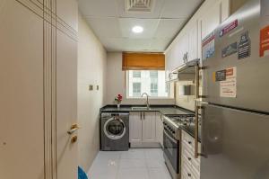 een kleine keuken met een wasmachine en droger. bij Royalton - Chic 2BR Marina Pinnacle Apartment with City Views in Dubai