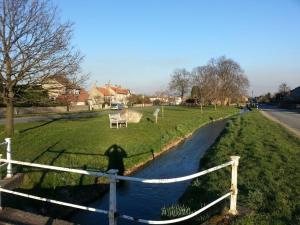 a fence next to a river next to a field at The Castle Arms Inn in Bedale