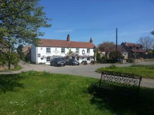 a black bench in front of a white house at The Castle Arms Inn in Bedale