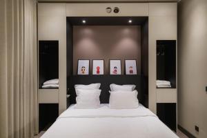 - une chambre avec un grand lit et des oreillers blancs dans l'établissement Maison Nô - Hôtel et Rooftop, à Lyon