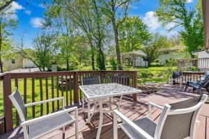 Un patio con una mesa y sillas en una terraza. en Downtown Branson Bungalow, en Branson