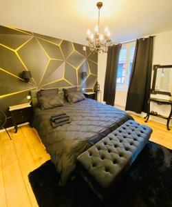 een slaapkamer met een groot bed en een kroonluchter bij Charmant appartement 4/6 pers. in Barr +18 foto's