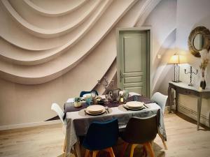 a dining room with a table and blue chairs at Charmant appartement 4/6 pers. in Barr