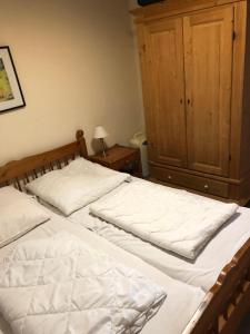 a bedroom with two beds and a wooden cabinet at Haus-Koralle-Wohnung-rechts in Boltenhagen