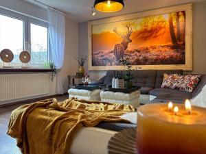 - un salon avec un canapé et un tableau de cerfs dans l'établissement Groepshuis Waldfrieden, à Medebach