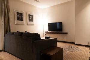 a living room with a couch and a flat screen tv at Dream Residence Khobar in Al Khobar