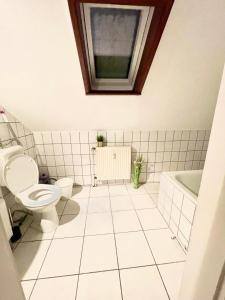 ein Bad mit einem WC, einem Waschbecken und einem Fenster in der Unterkunft Ferienwohnung für 5 Personen, gemütlich und möbliert in Stein bei Nürnberg