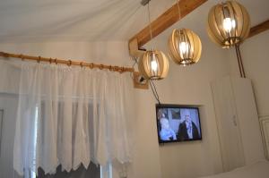 a television hanging on a wall with a window at Studio Mini Lux in Požarevac