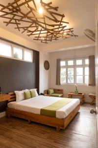 a bedroom with a large bed under a wooden ceiling at The Living Roof in Shillong