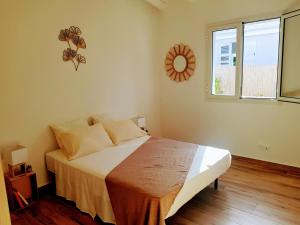 a bedroom with a bed and a large window at La villa d'Emma in Sainte-Anne