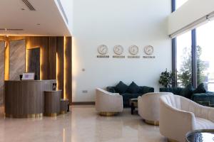 a lobby with couches and clocks on the wall at Dream Residence Khobar in Al Khobar