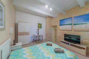 - un salon avec un grand lit et une télévision dans l'établissement Typical Maltese town house just outside Valletta, à Il-Furjana