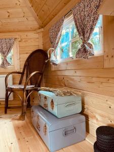 une chambre avec une chaise et des valises dans une cabine dans l'établissement Cabane dans un jardin arboré, à LʼAbsie