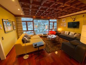 a living room with a yellow couch and a tv at Vistas del Toneo in Puebla de Lillo
