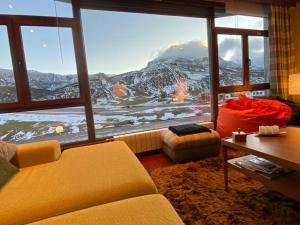 a living room with a large window with a mountain view at Vistas del Toneo in Puebla de Lillo